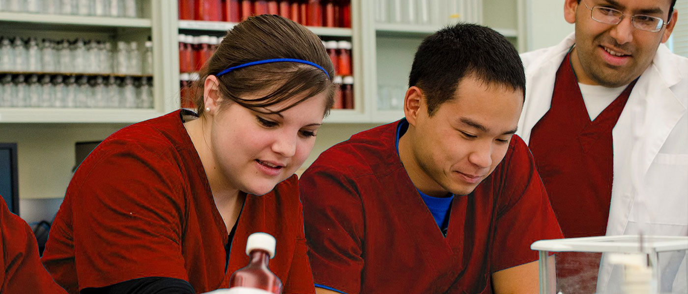 Pharmacy Tech students in red scrubs in the classroom